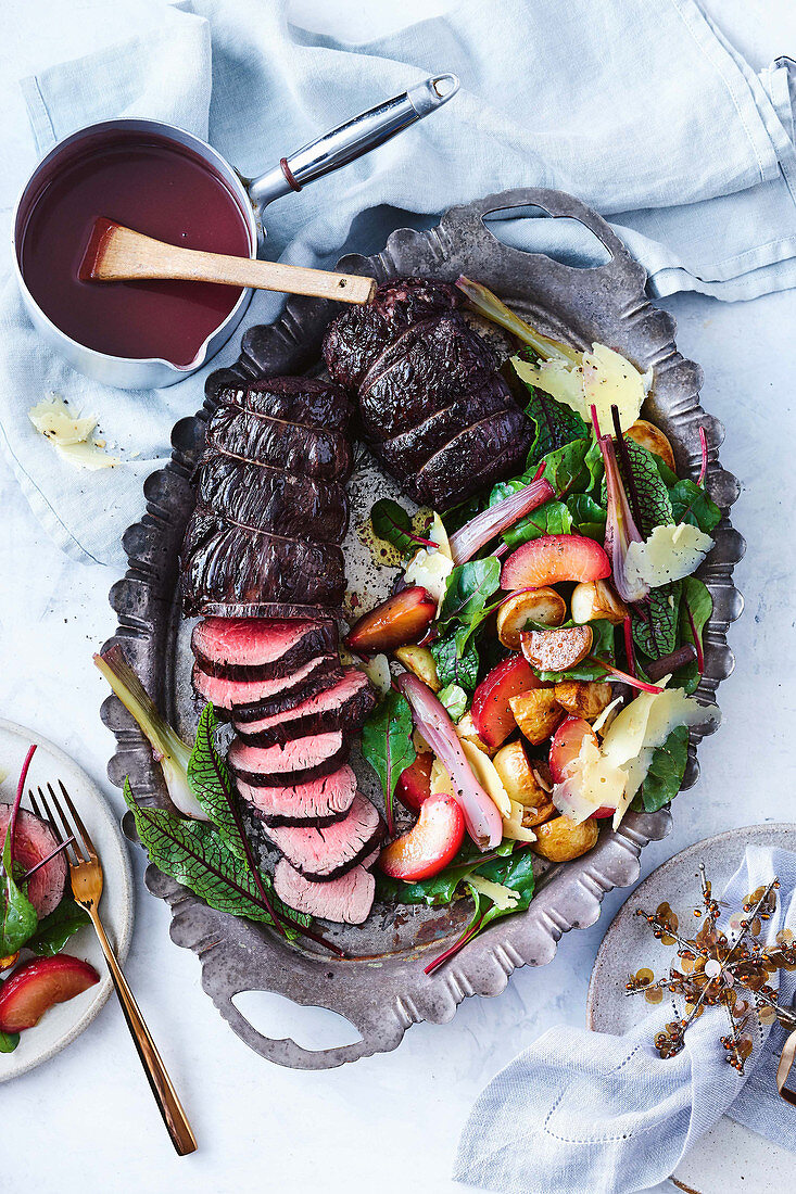 In Rotwein pochiertes Rinderfilet mit Gemüse und Pflaumen