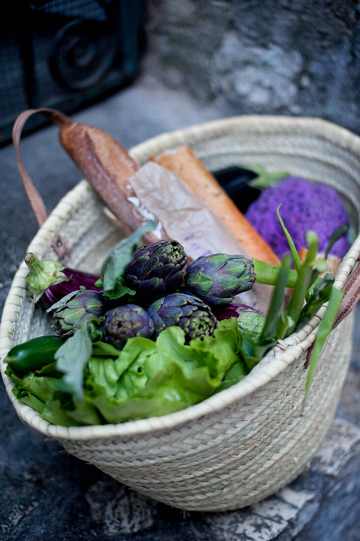 Bread, salad and fresh vegetables in a shopping basket
