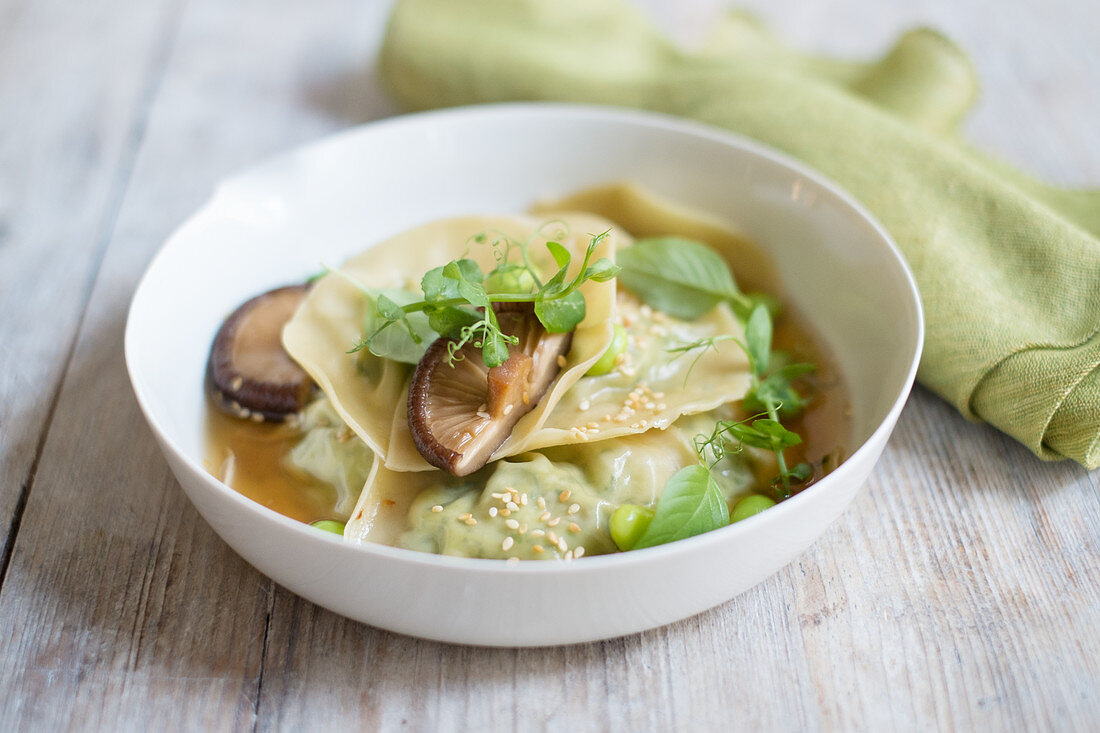 Dumplings in Brühe mit Edamame, Pilzen und Brunnenkresse