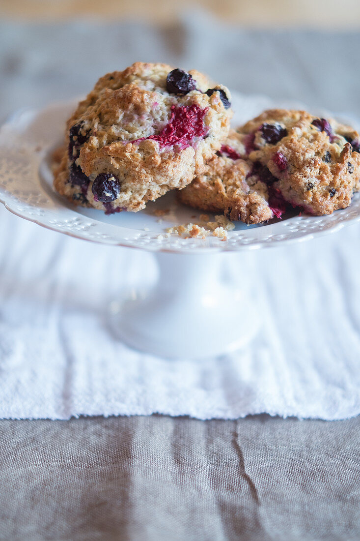 Scones with blueberries and raspberries on a cake stand