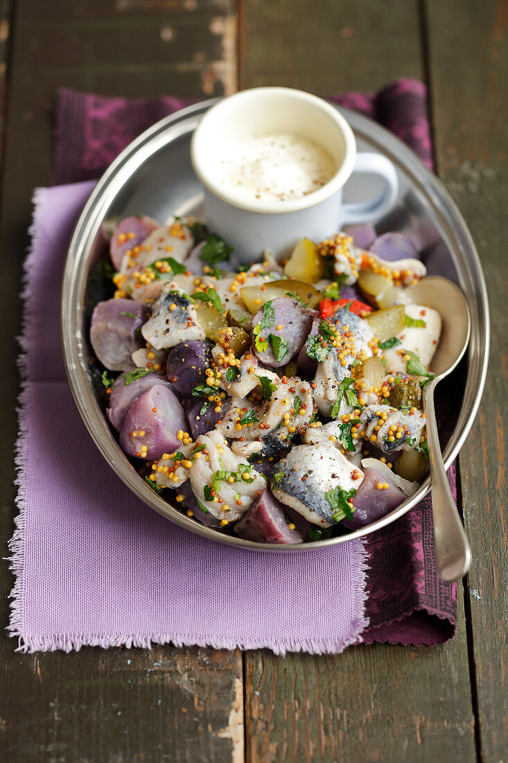 Herring and purple potatoes salad with pickled cucumber and mustard