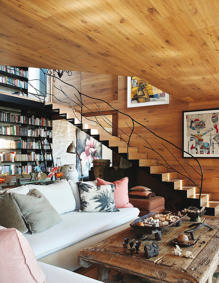 Sofa, rustic coffee table, bookcase and staircase