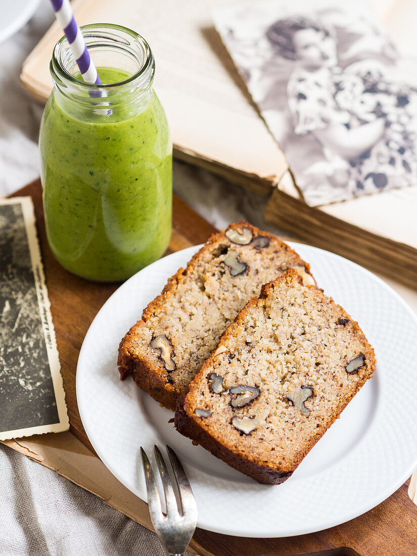 Two slices of flourless (almond and coconut flour) banana bread with nuts, served with green smoothie