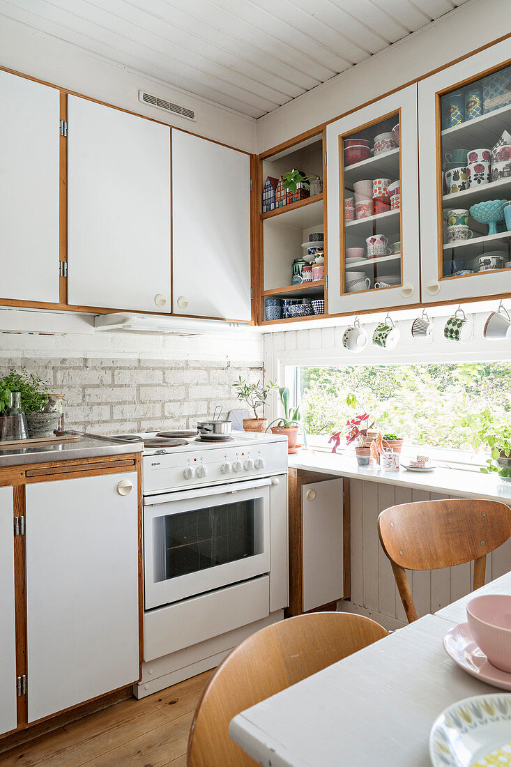 Gemütliche Wohnküche in Weiß mit horizontalem Fenster
