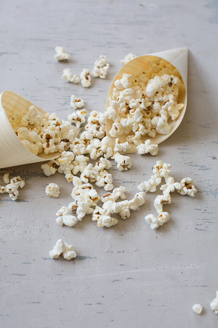 Popcorn in Papiertüte und auf hellem Untergrund