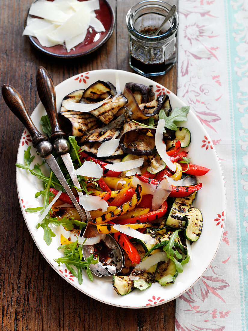 A grilled vegetable platter with parmesan shavings