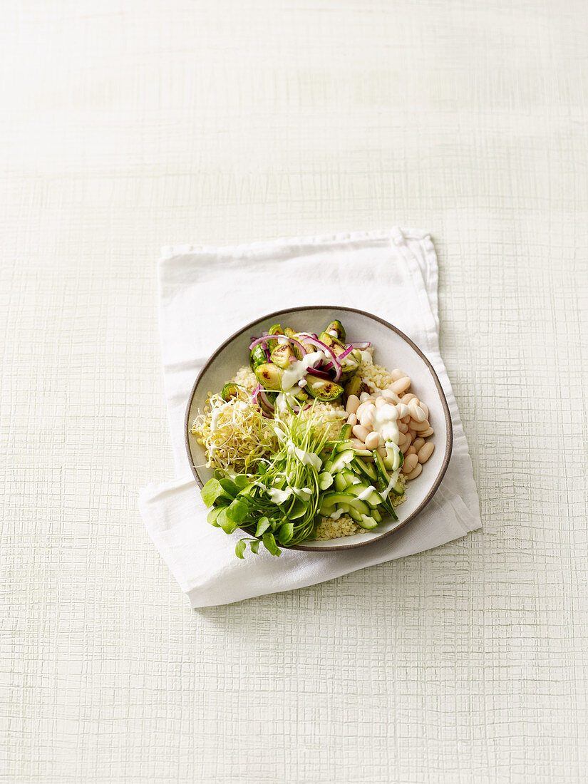 Brussels sprouts bowl with bulgur, beans, beansprouts and yoghurt
