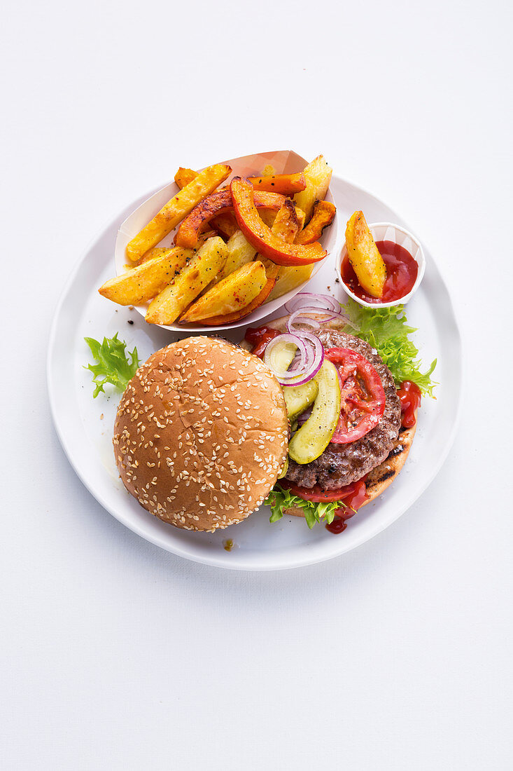 A burger with vegetable fries and tomato sauce