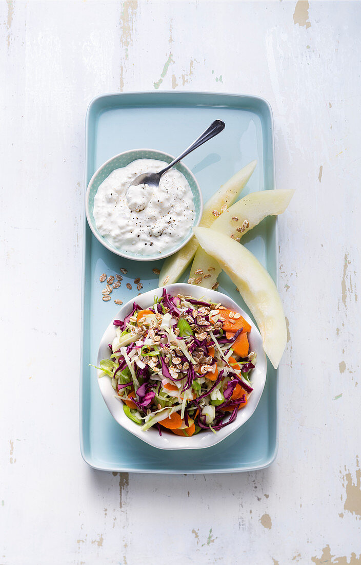 Colourful coleslaw with honeydew melon slices and a yoghurt dressing