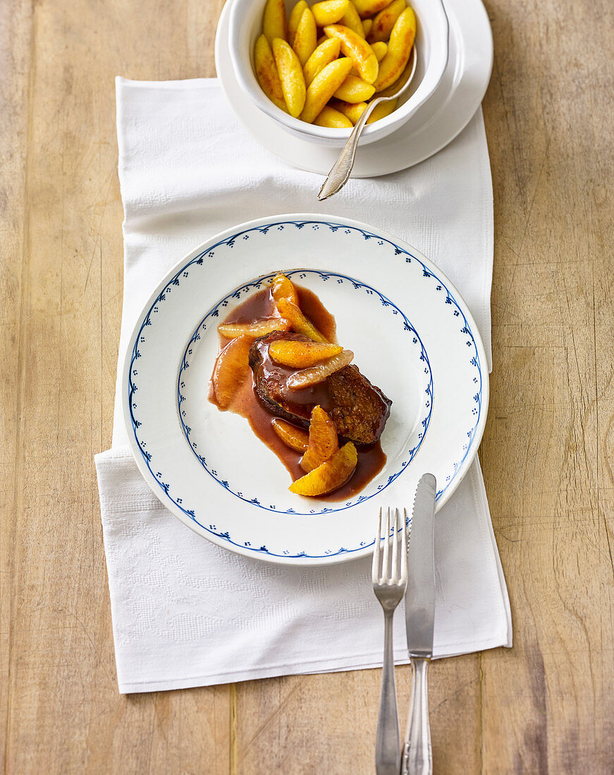 A duck breast fillet in red wine and orange sauce