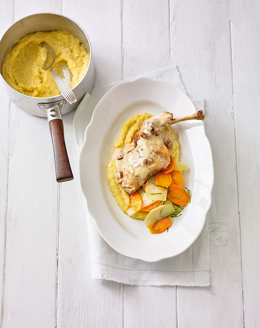 A braised rabbit leg with polenta and spring vegetables