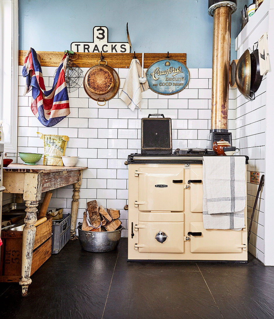 Old wood stove and vintage table in kitchen with white tiled wall