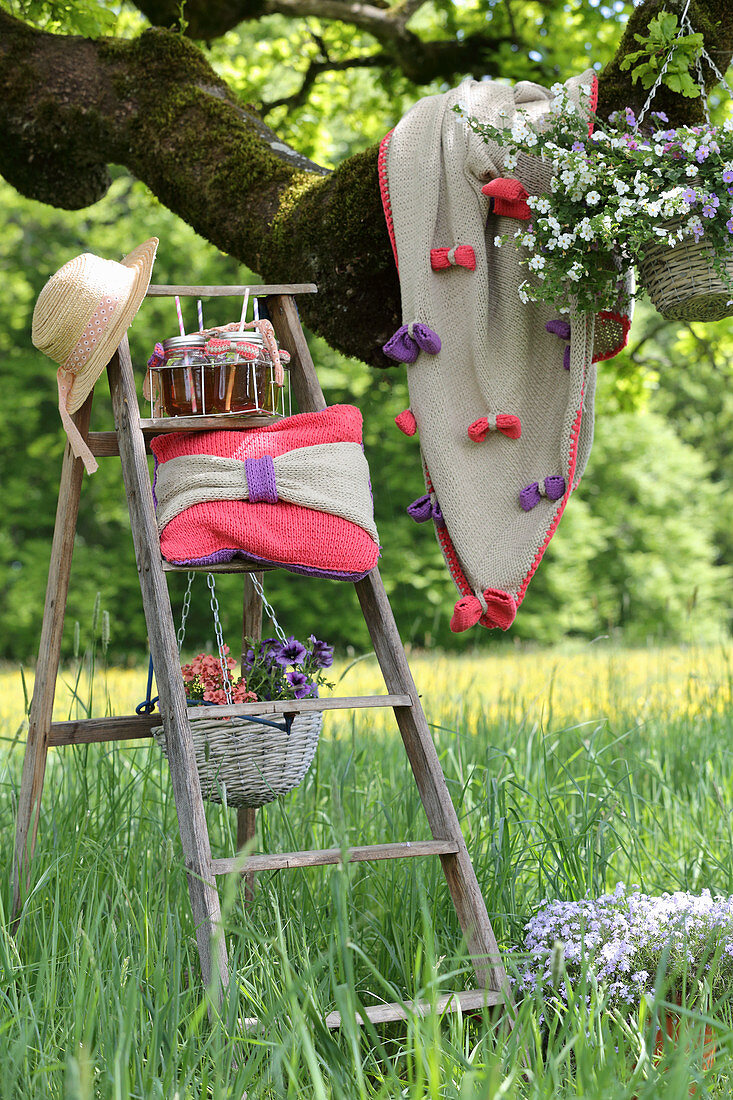 Crocheted cushions and blanket with bows under tree