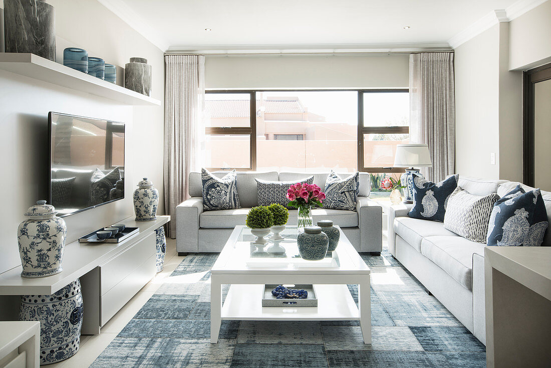 Sofa set and coffee table in elegant TV room in light shades