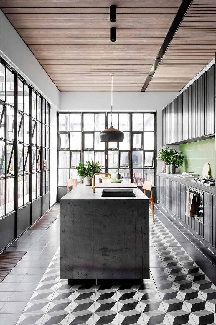 Schwarze Küchenzeile mit grünen Wandfliesen und Kücheninsel in offener Küche mit Industriefenster