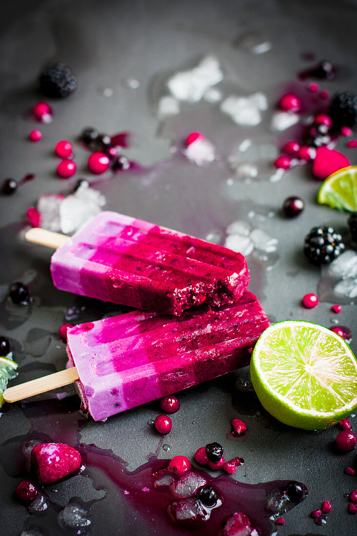 Yoghurt and berry ice cream sticks, one with a bite taken out