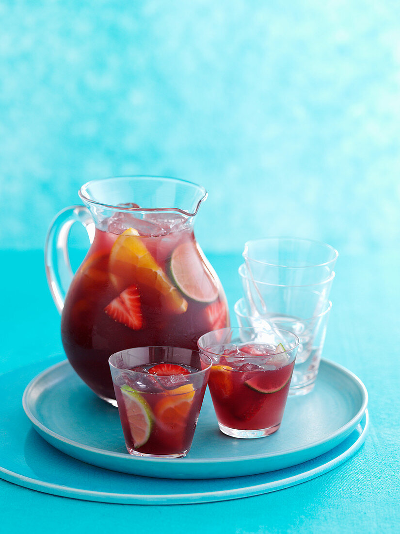 A jug of sangria with several glasses