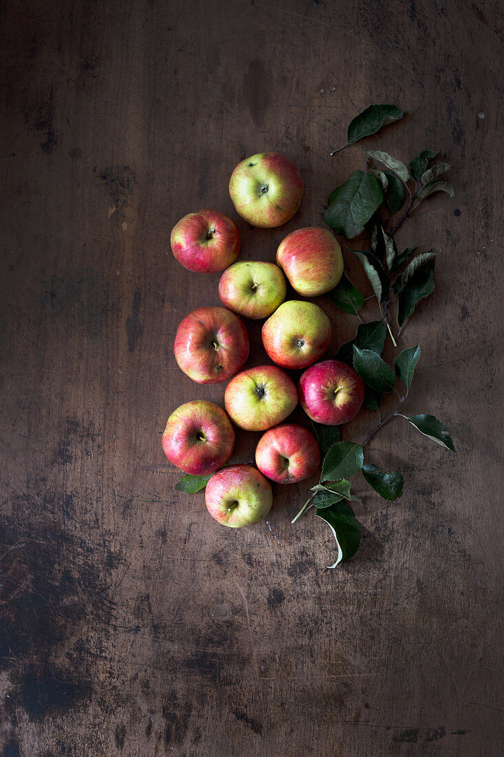 Organic apples on a dark wooden surface (seen from above)