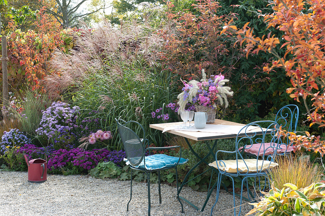 Seating on the autumnal bed with perennials and grasses