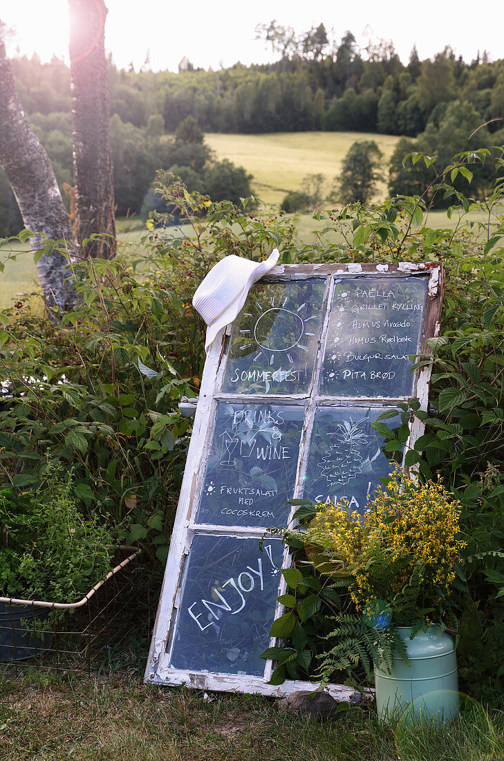 Menu written on old lattice window in garden