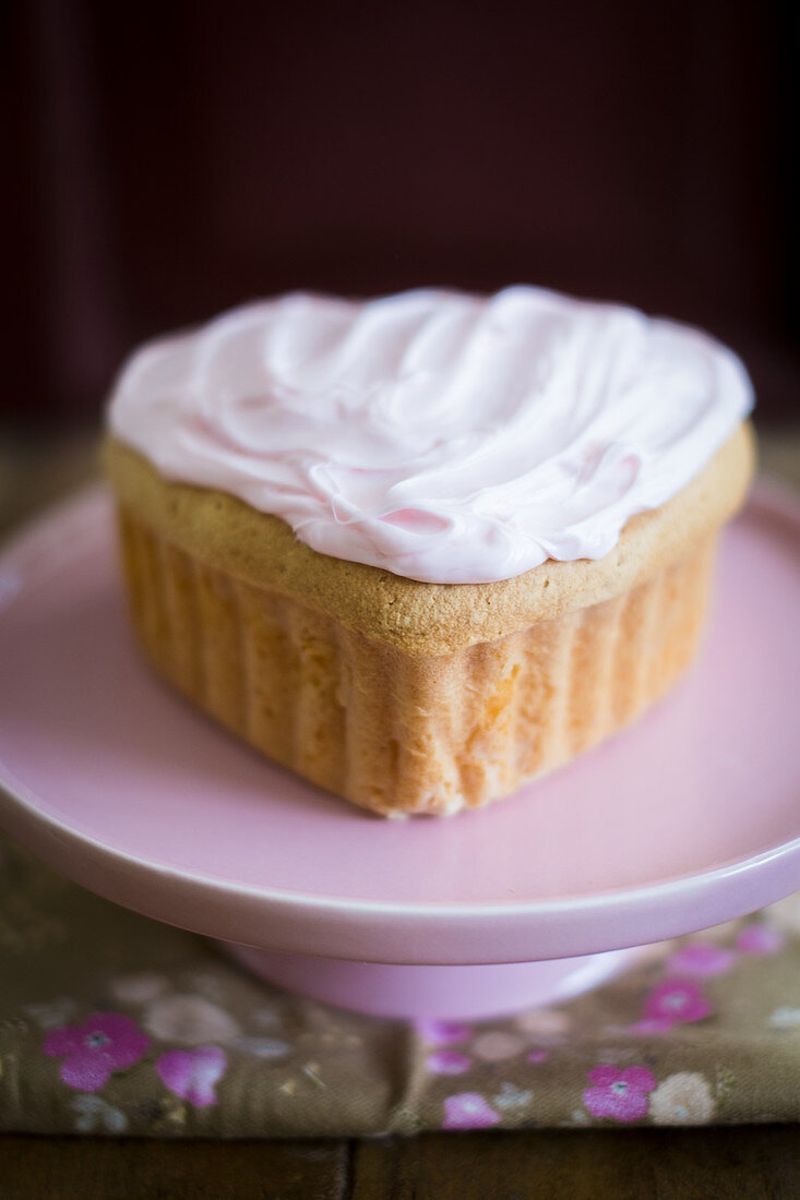 A mini heart-shaped cake with frosting