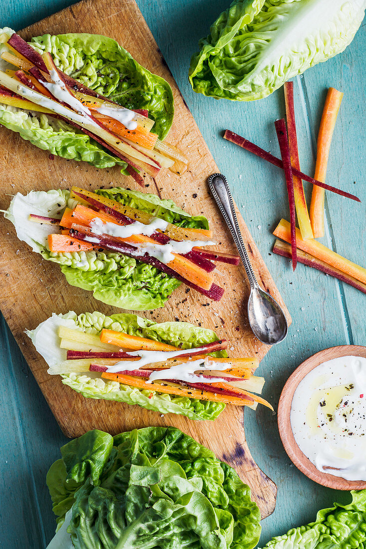 Mini roman salad tacos with carrots, natural yoghurt dip with colorful pepper and olive oil