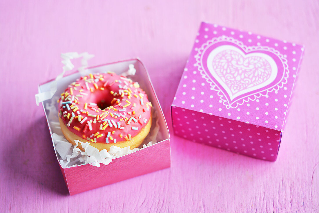 Mini-Donut mit Zuckerglasur und Zuckerstreuseln in Geschenkbox