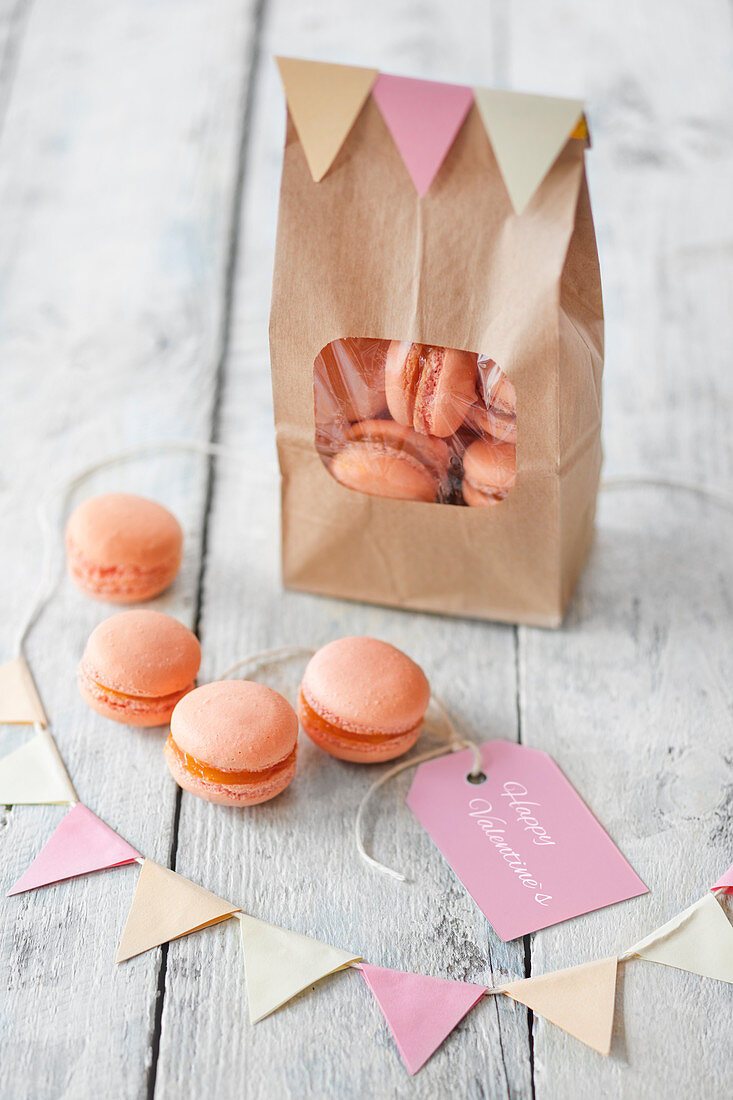 Aprikosen-Macarons zum Valentinstag in Papiertüte und davor
