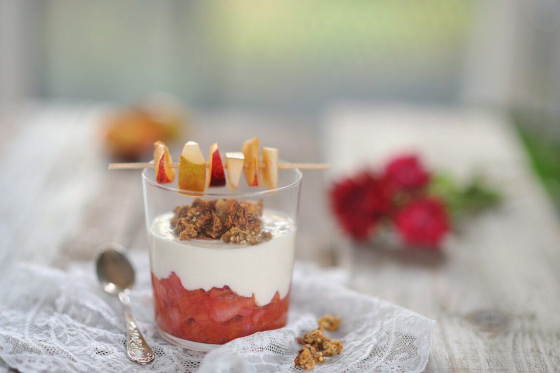 Veganes Pflaumen-Birnen-Kompott im Glas mit Kokosjoghurt, Granola und Fruchtspieß