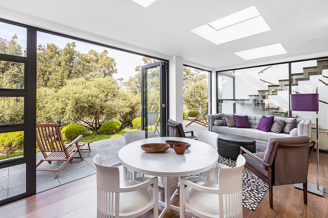 Wohnzimmer mit offener Fensterfront zur Terrasse