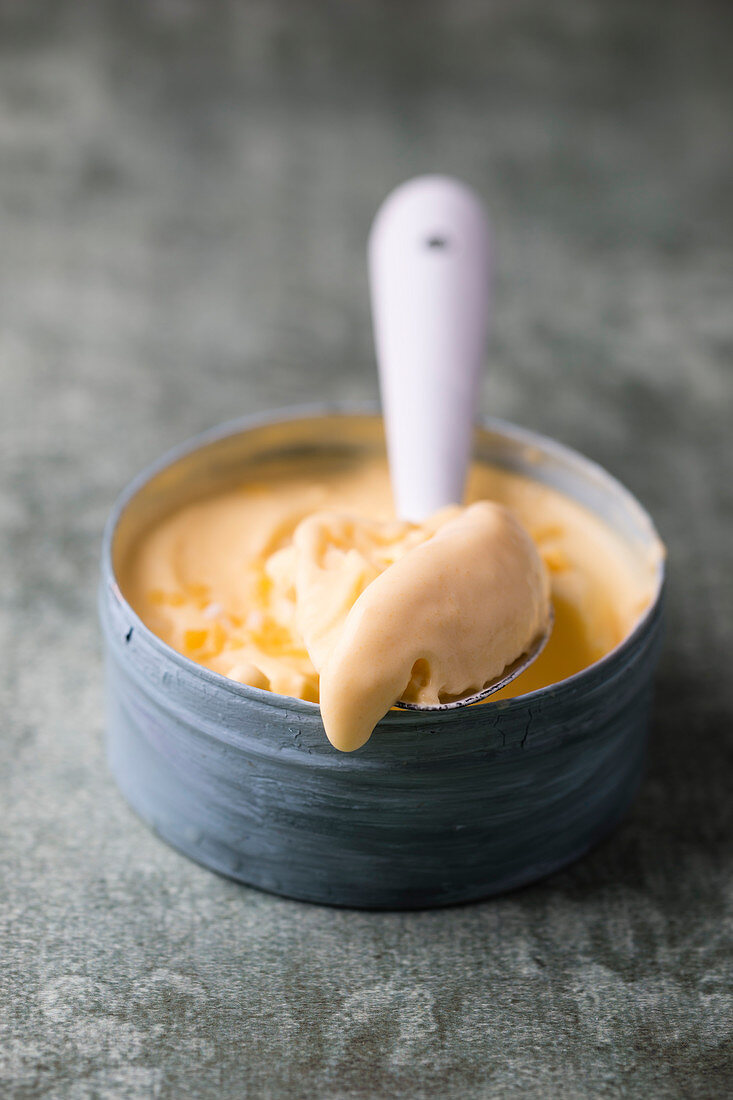 Lemon ice cream in a bowl with a spoon