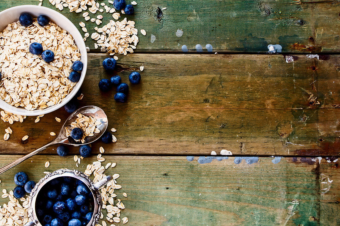 Oatmeal and blueberries in bowls against a rustic wooden background