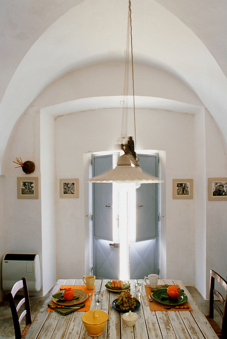 Set table in front of window with vaulted frame and shutters