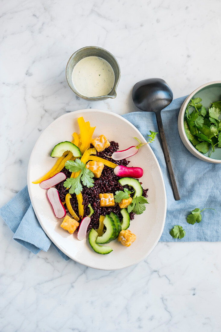 Black rice salad with raw vegetables and chickpea tempeh