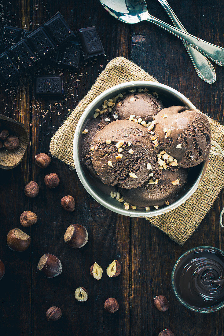 Schokoladen-Haselnuss-Eis in Silberschale mit gehackten Nüssen