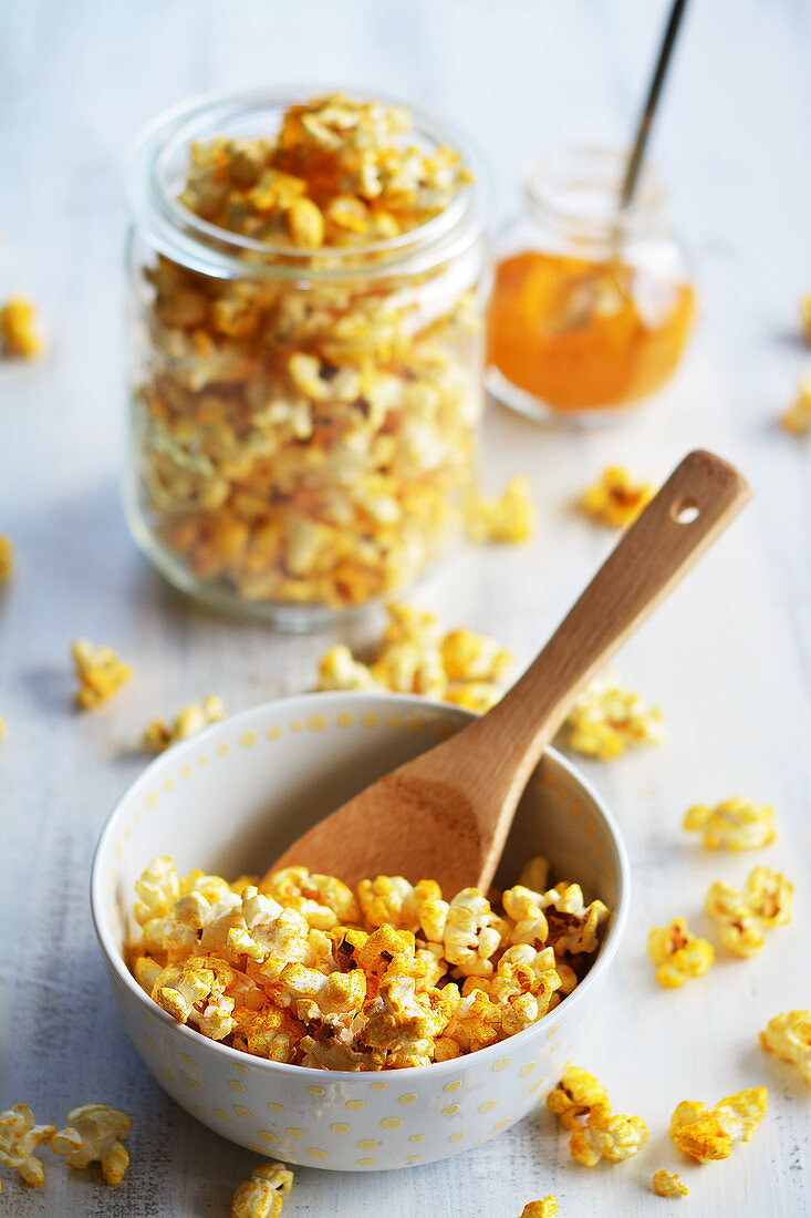 Popcorn with curry and salt in a bowl and a jar