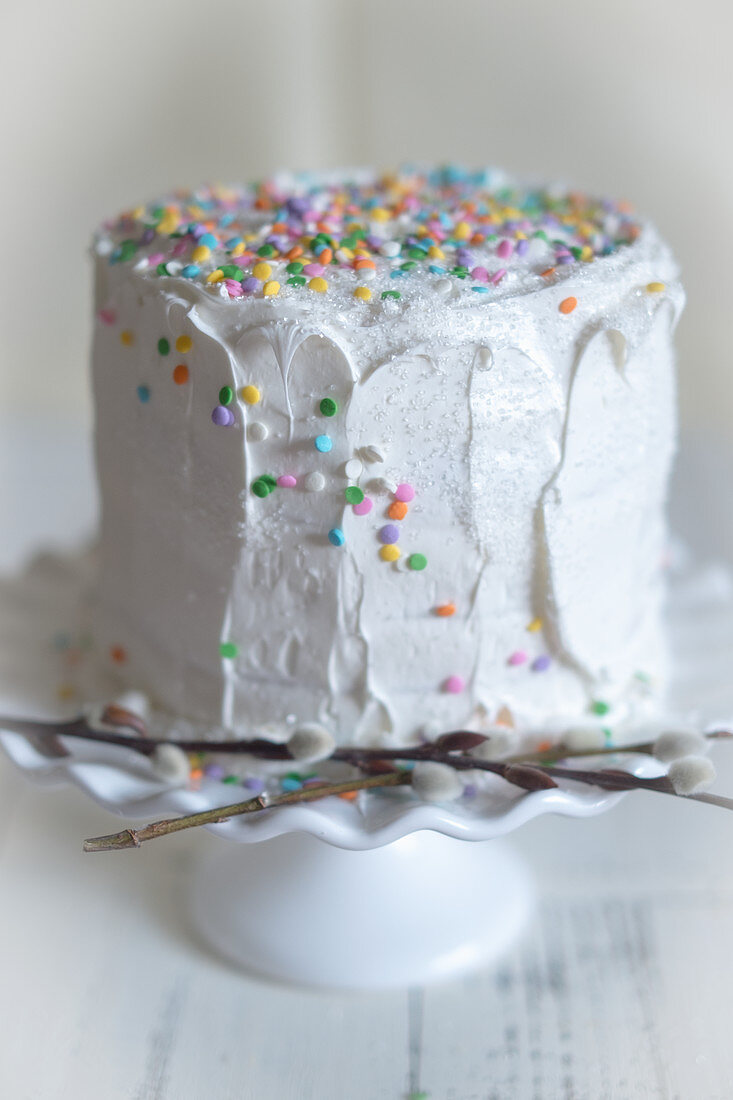 weiße Torte mit Zuckerkonfetti und Palmkätzchen