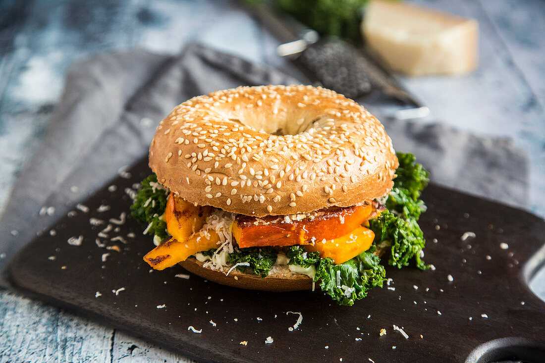 A green kale and grilled vegetable bagel