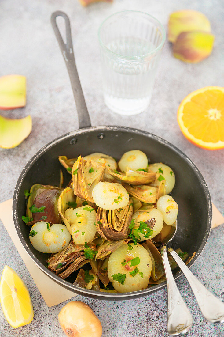 Contour of artichokes small onions and anchovies with citrus peel and parsley