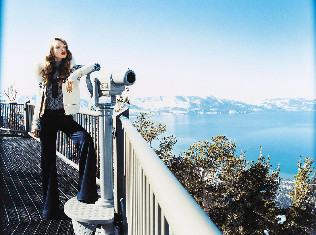 Junge Frau in Strickjacke und Marlene-Jeans am Aussichtsplattform