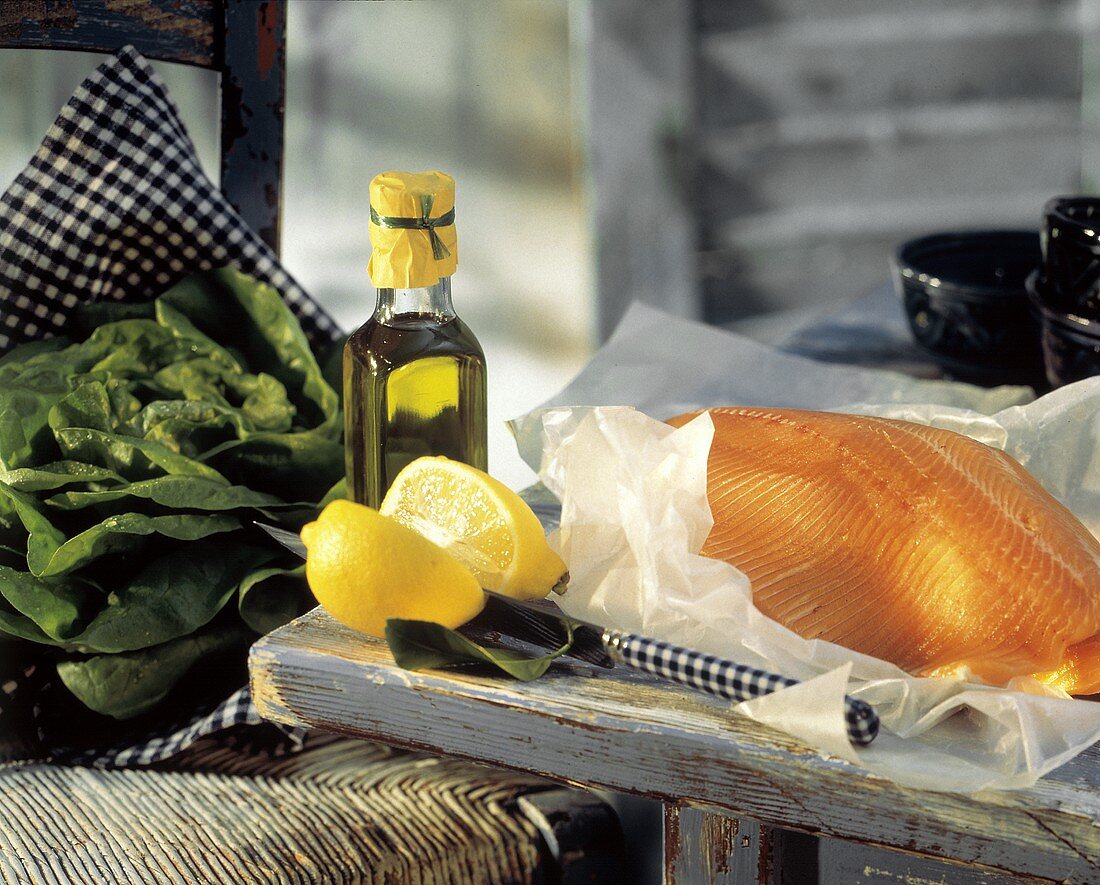 Stillleben mit Lachsfilet, Zitrone, Olivenöl & Salatkopf