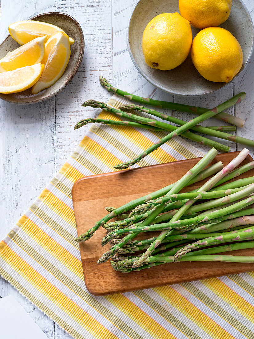 Green asparagus on striped placemat with lemons