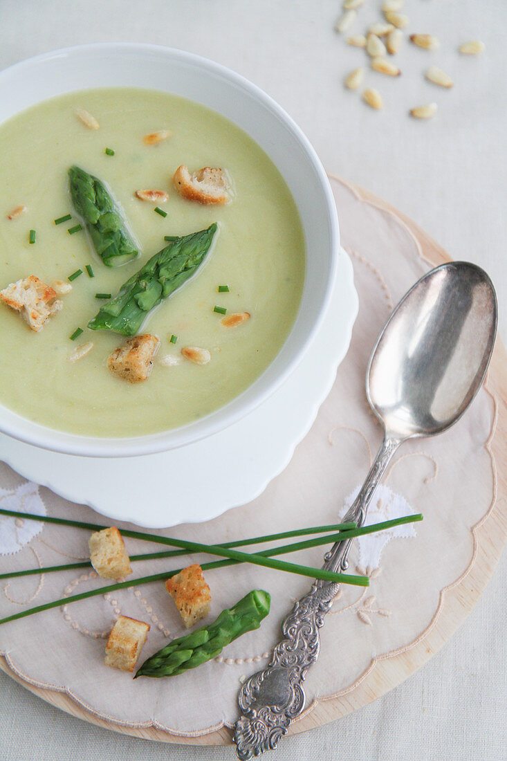Cream of asparagus soup with croutons and pine nuts