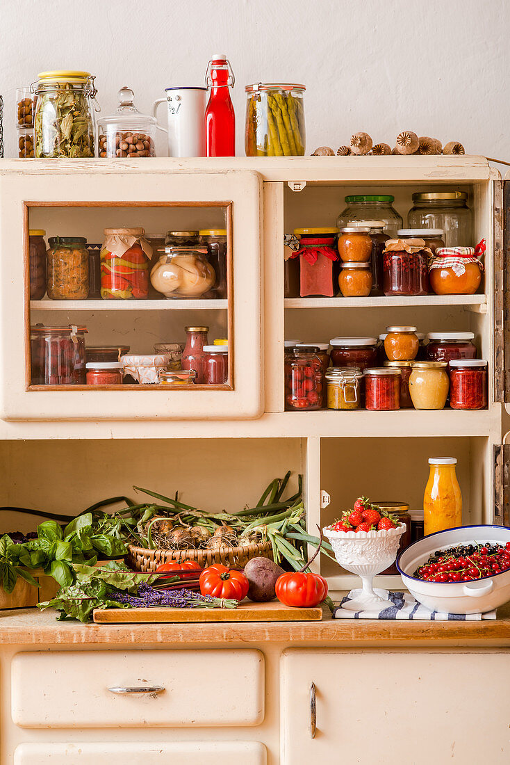 Preserves, fresh fruit and vegetables on a kitchen dresser