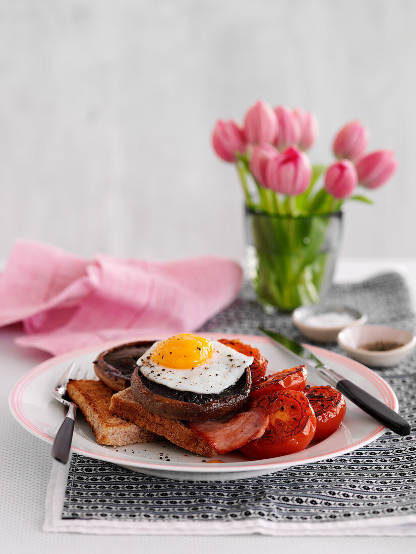 Frühstück mit Toast, Pilzen, Bacon, Tomaten und Spiegelei (England)