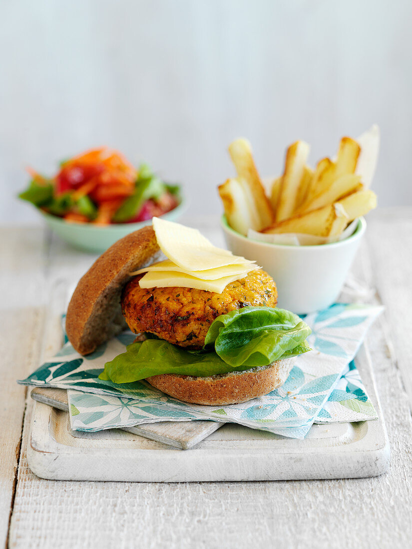 A bean burger with chips and salad