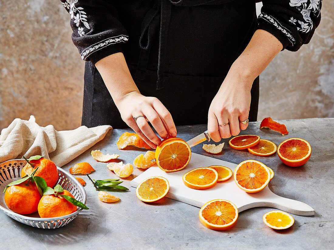 A woman slicing blood oranges