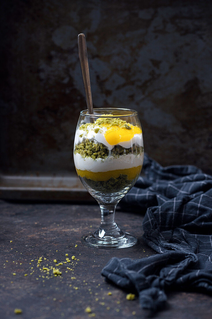 Vegan dessert in a glass made with matcha cake, mango purée and soya yoghurt