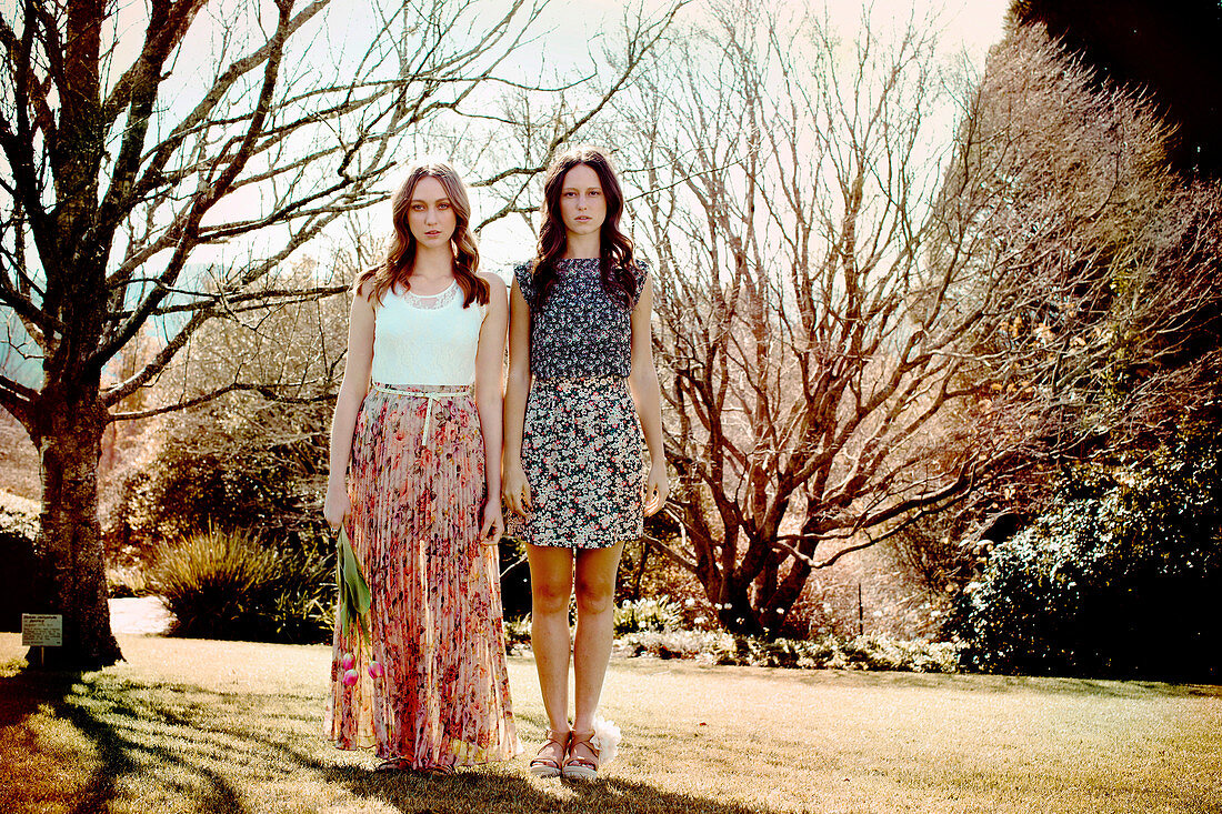 Zwei junge Frauen in sommerlichen Outfits im Park
