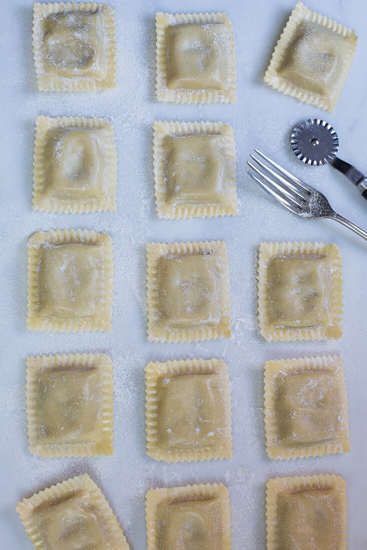 Selbstgemachte Tortelloni mit Gabel und Teigrädchen